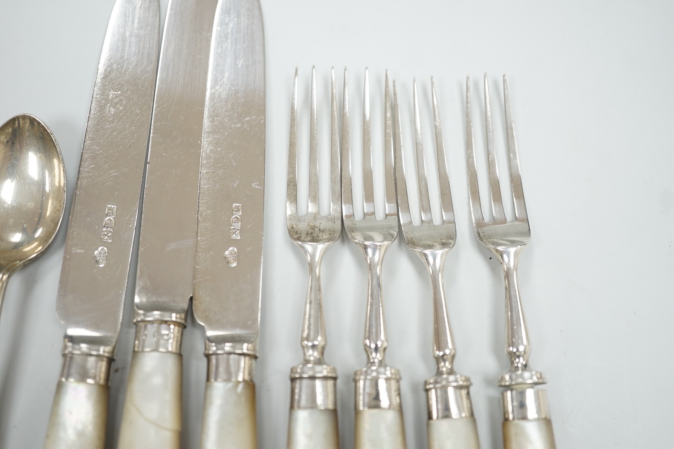 A set of six George V golfing related teaspoons, Walker & Hall, Sheffield, 1933 and seven mother of pearl handled silver dessert eaters.